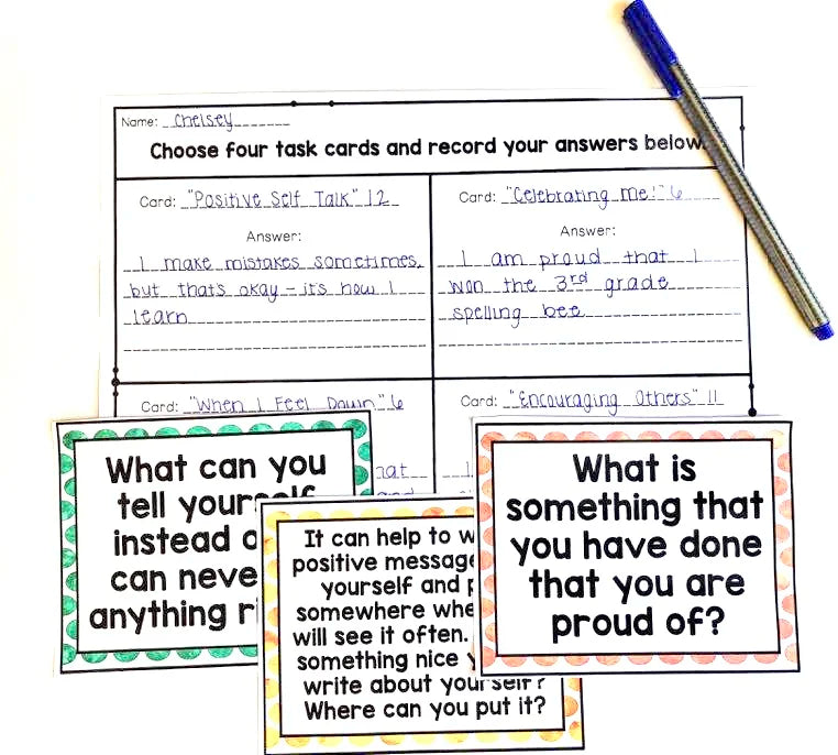 Educational task cards with writing prompts and a pen on a white background