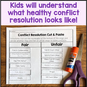Conflict resolution worksheet with scissors and glue stick on a wooden surface