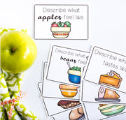 Green apple next to educational cards with food illustrations and text.