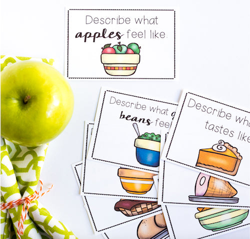 Green apple next to educational cards with food illustrations and text.