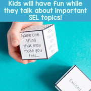 Hand holding a cube with text on it against a blue background