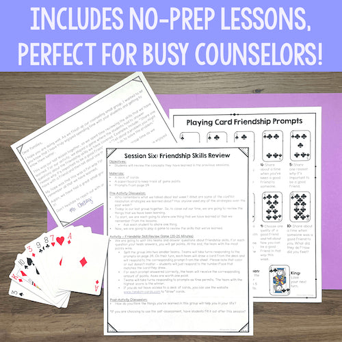 Educational materials including playing cards and worksheets on a wooden surface with a purple mat.