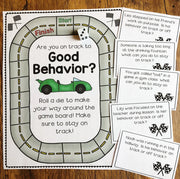 Children's game board titled 'Are you on track to Good Behavior?' with die and cards on a wooden surface.