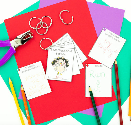 Colorful paper with keychains, a hole punch, and writing materials on a multicolored background