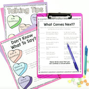 Educational materials on a clipboard with colorful heart-shaped cards and pens.