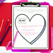 Children's activity sheet on a clipboard with writing about being a 'Heart' friend, surrounded by colored pencils and markers.