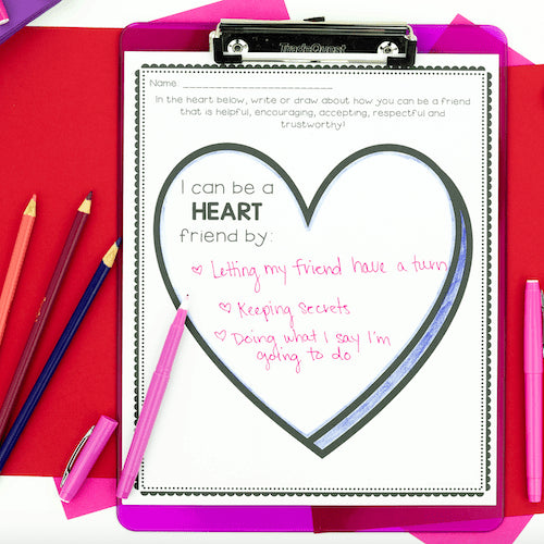 Children's activity sheet on a clipboard with writing about being a 'Heart' friend, surrounded by colored pencils and markers.